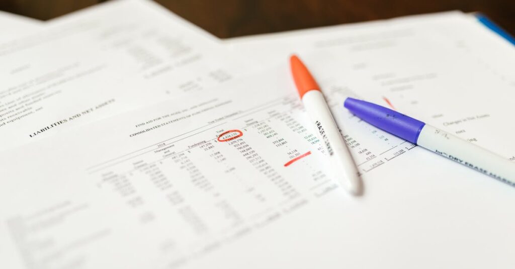 Close-up of financial documents with pens highlighting important data points.